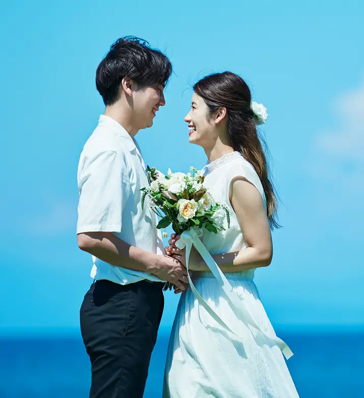 ブーケを持った花嫁と花婿が見つめあっている様子